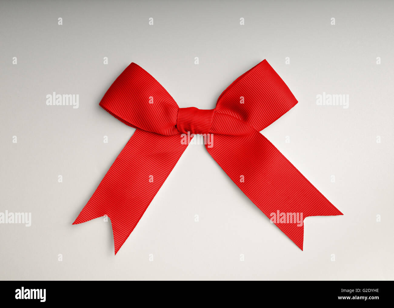 Arco rosso sul tavolo con gradiente dello sfondo Foto Stock