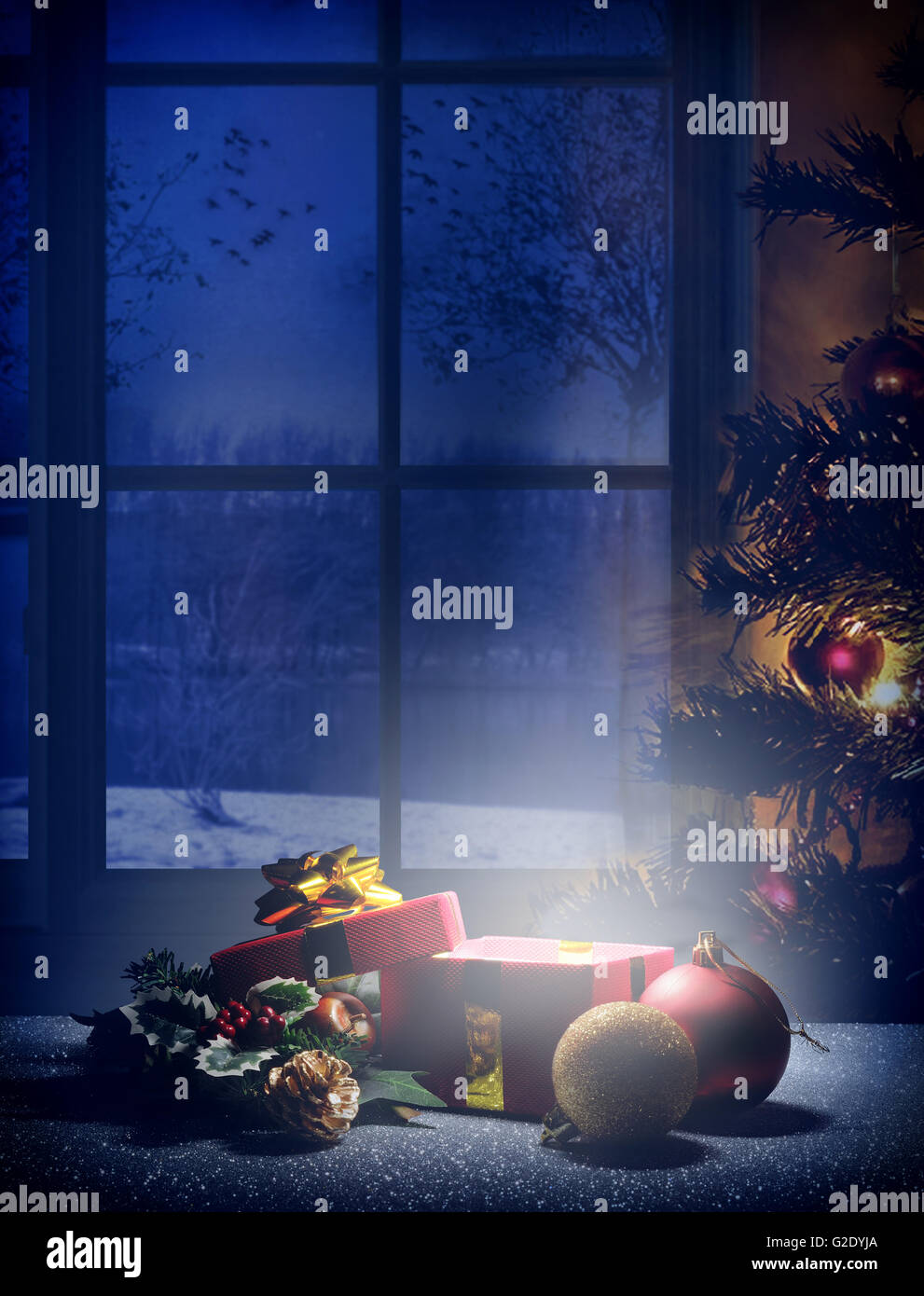 Composizione di Natale alla vigilia di Natale. Candela di dono, albero e palle di decorazione con lo sfondo della finestra. Tonalità bluastra sogno. In verticale Foto Stock