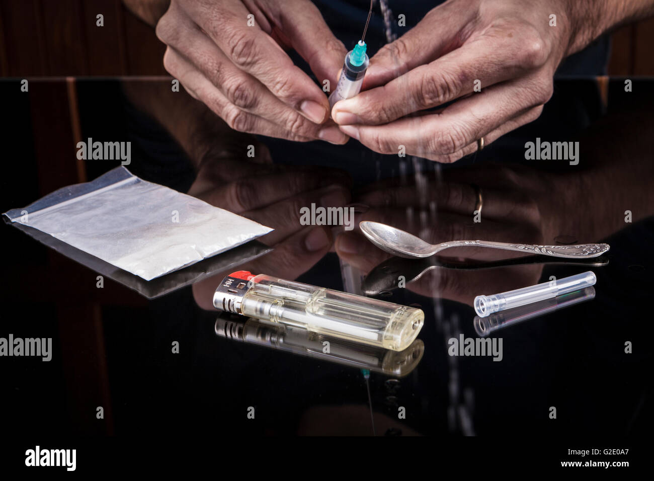 Preparazione di farmaci in una siringa su sfondo scuro con la riflessione Foto Stock