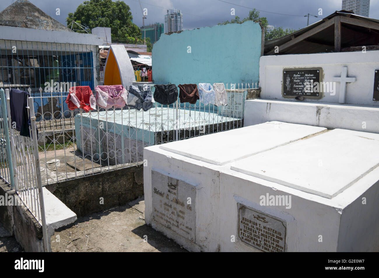 Le persone che vivono nei cimiteri non è raro nelle Filippine.Lavaggio Asciugatura si blocca tra tombe nel cimitero Carreta,Cebu City Foto Stock