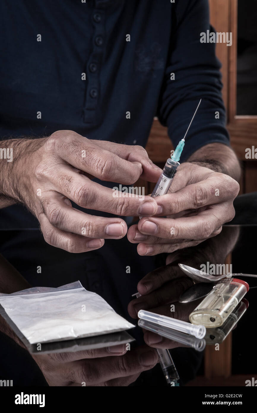 Preparazione di farmaci in una siringa su sfondo scuro con la riflessione Foto Stock