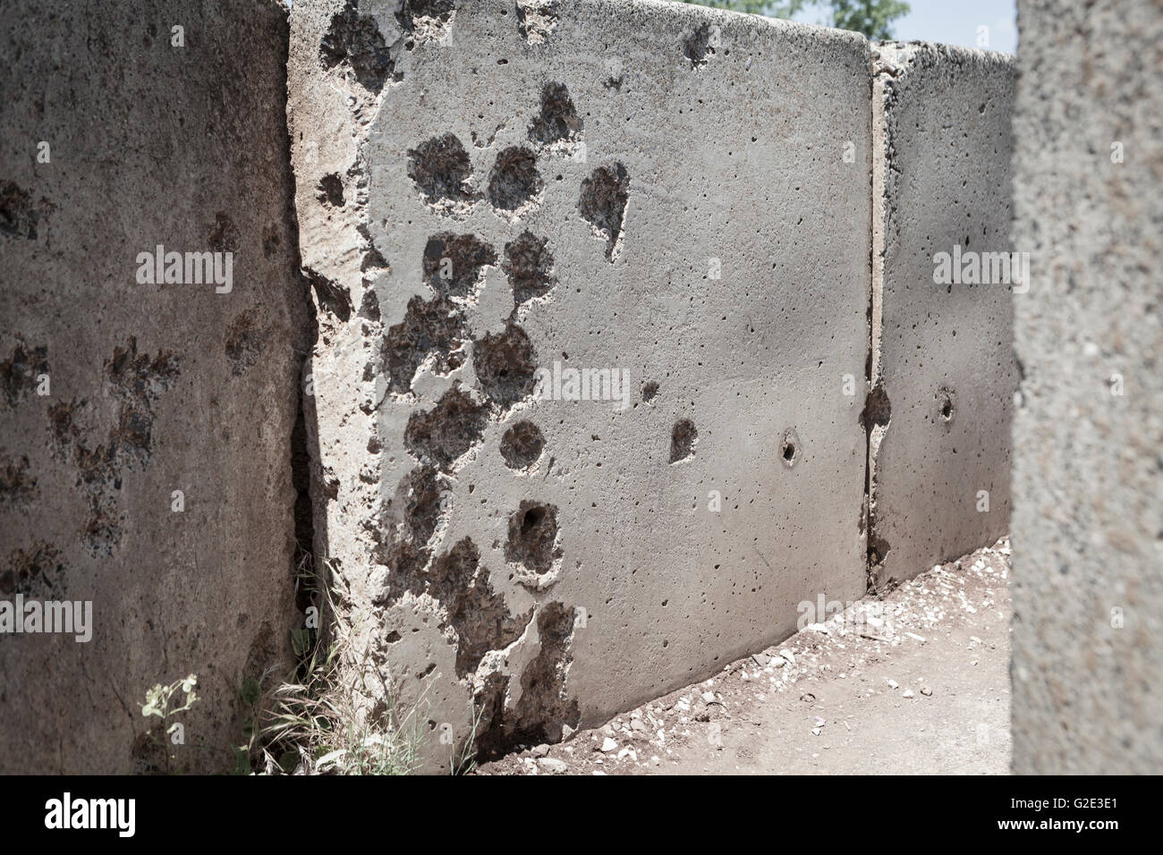 Parete in cemento piena con la vecchia guerra fori di proiettile Foto Stock