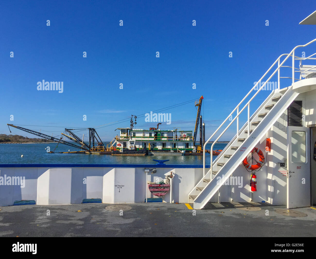 Ferry boat con vista di una vicina chiatta di lavoro Foto Stock