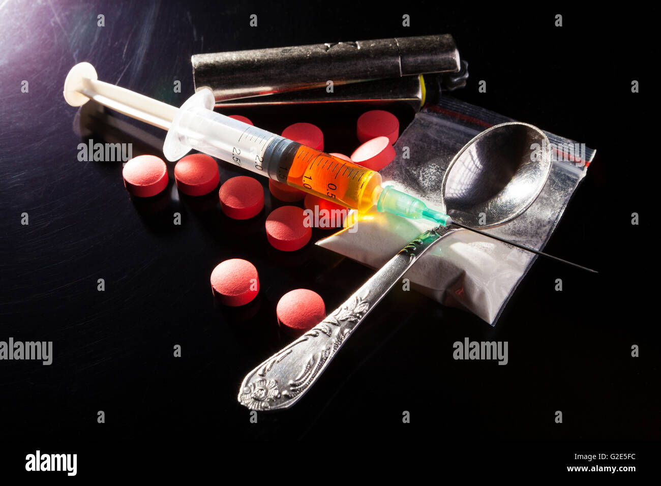 Durgs con cucchiaio e siringa su sfondo scuro con ightning laterale Foto Stock
