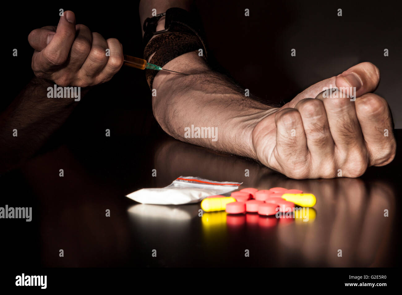Iniettare farmaci con siringa con pillole colorate e sacchetto di polvere Foto Stock