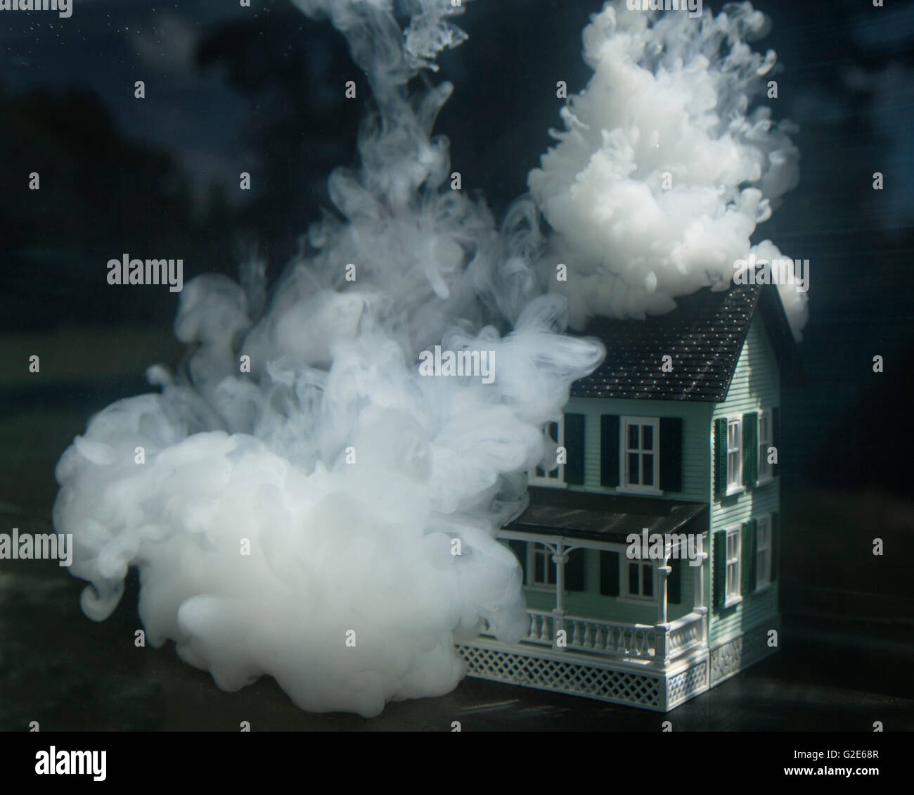 Casa in miniatura sotto l'acqua sul fuoco Foto Stock