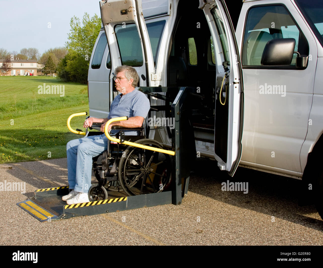 Handicap van con un uomo in sedia a rotelle su un dispositivo di  sollevamento Foto stock - Alamy