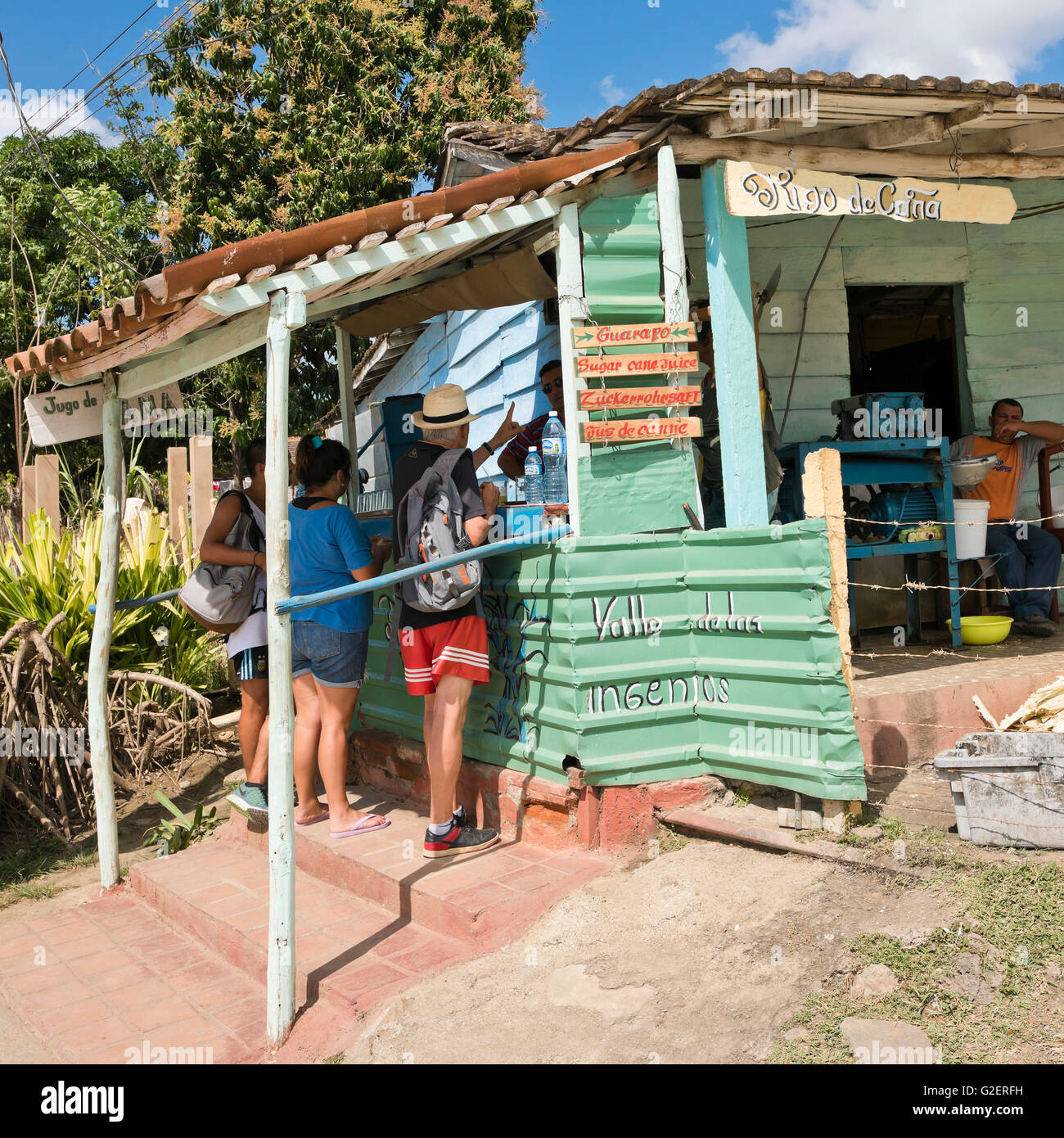 Vista sulla piazza di turisti acquisto di zucchero succo di canna in una caffetteria ramshackled in Valle de los Ingenios, Cuba. Foto Stock