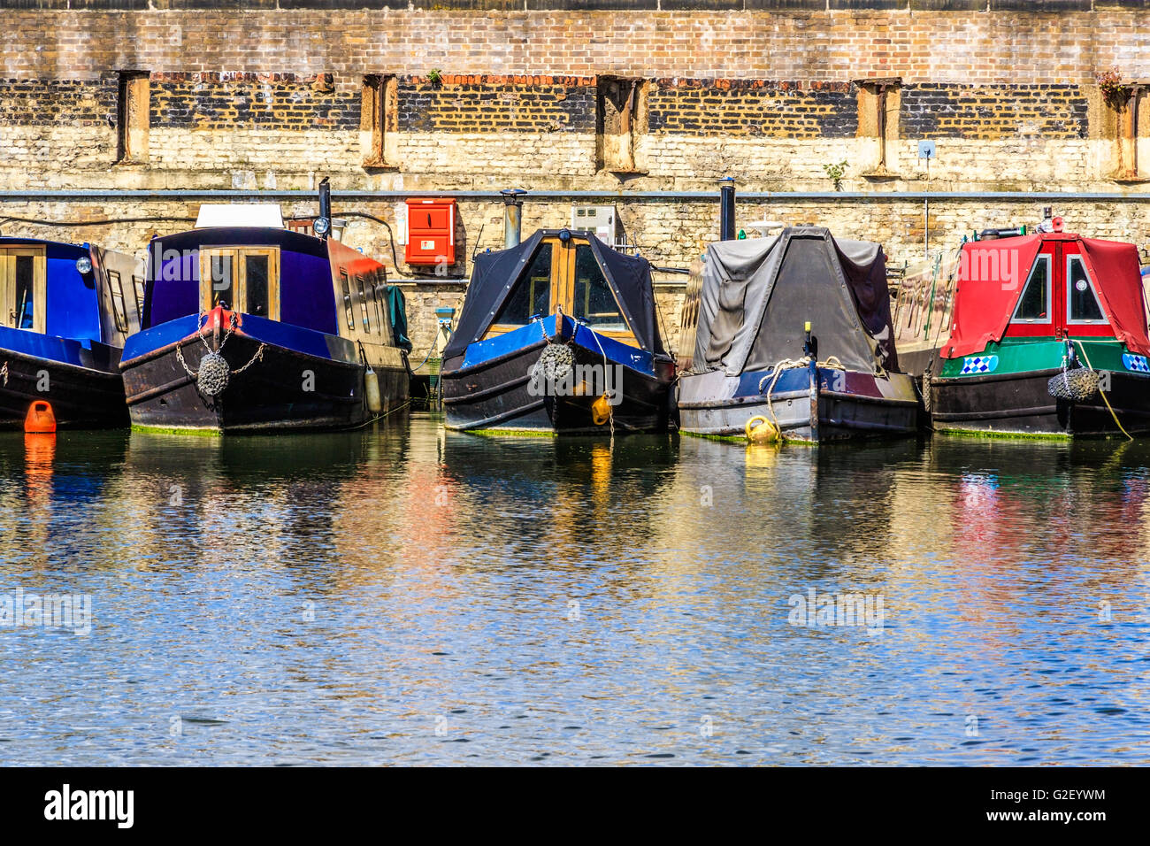 Le file di case galleggianti e imbarcazioni strette sulle rive del canale a St Pancras Yacht Basin, parte del Regent's Canal a Londra Foto Stock