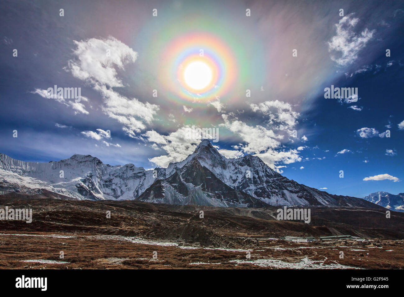 Colorata corona solare sull'Himalaya. In primo piano è il famoso monte Himalayano peak Ama Dablam (Madre Collana) Foto Stock