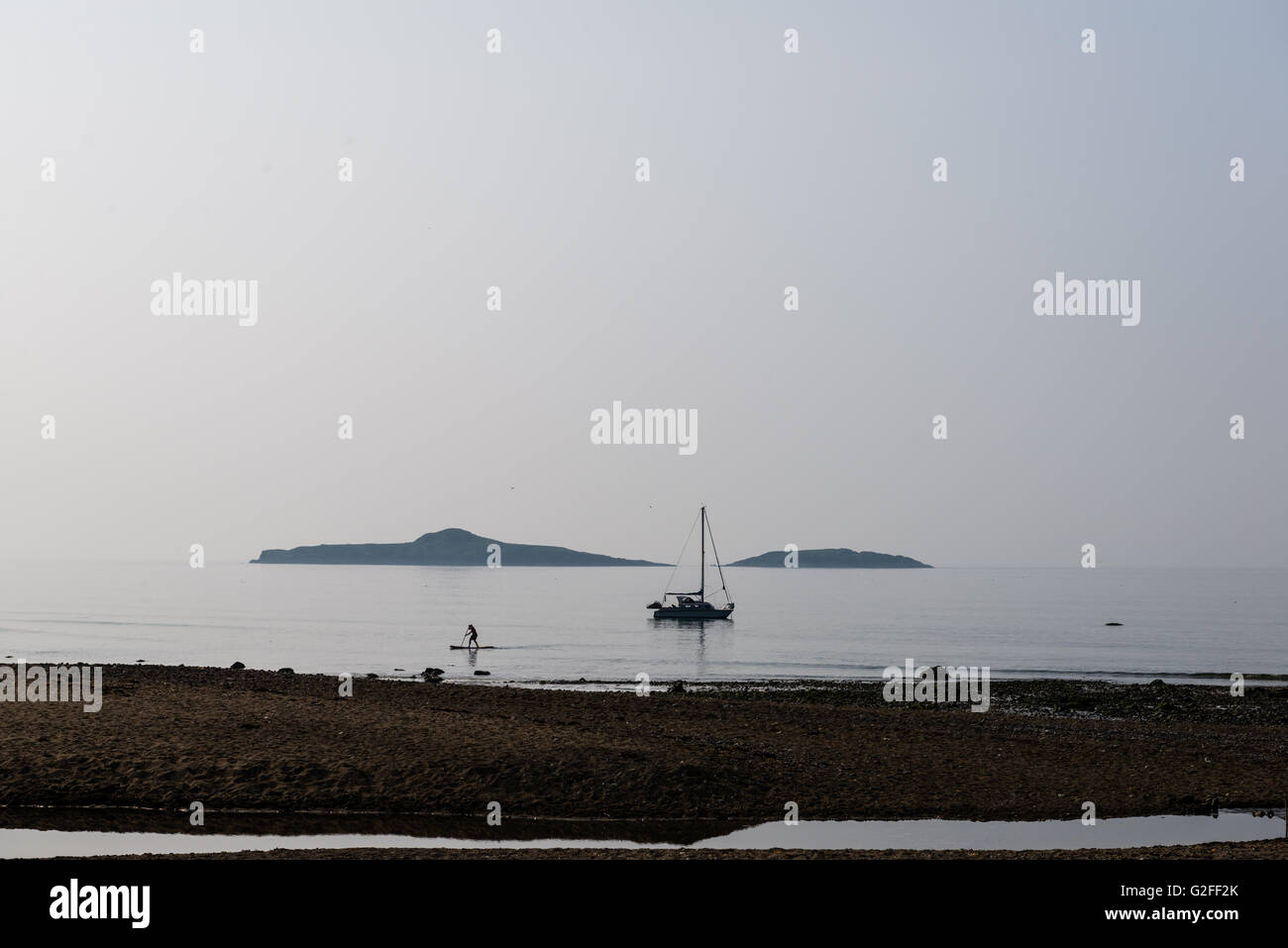 Barca e navigare boarder nel early sole di mattina, foschia ha unito il cielo e mare all'orizzonte. Foto Stock