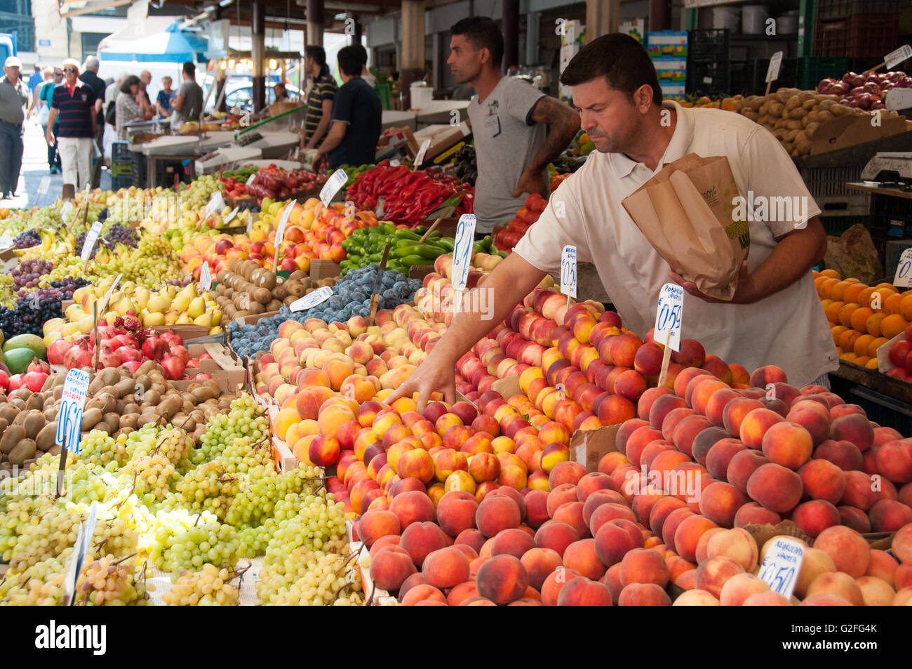Uomini greco vende frutta al pesce e frutti street market in Omonia Monastriki Agorà di Atene. Foto Stock