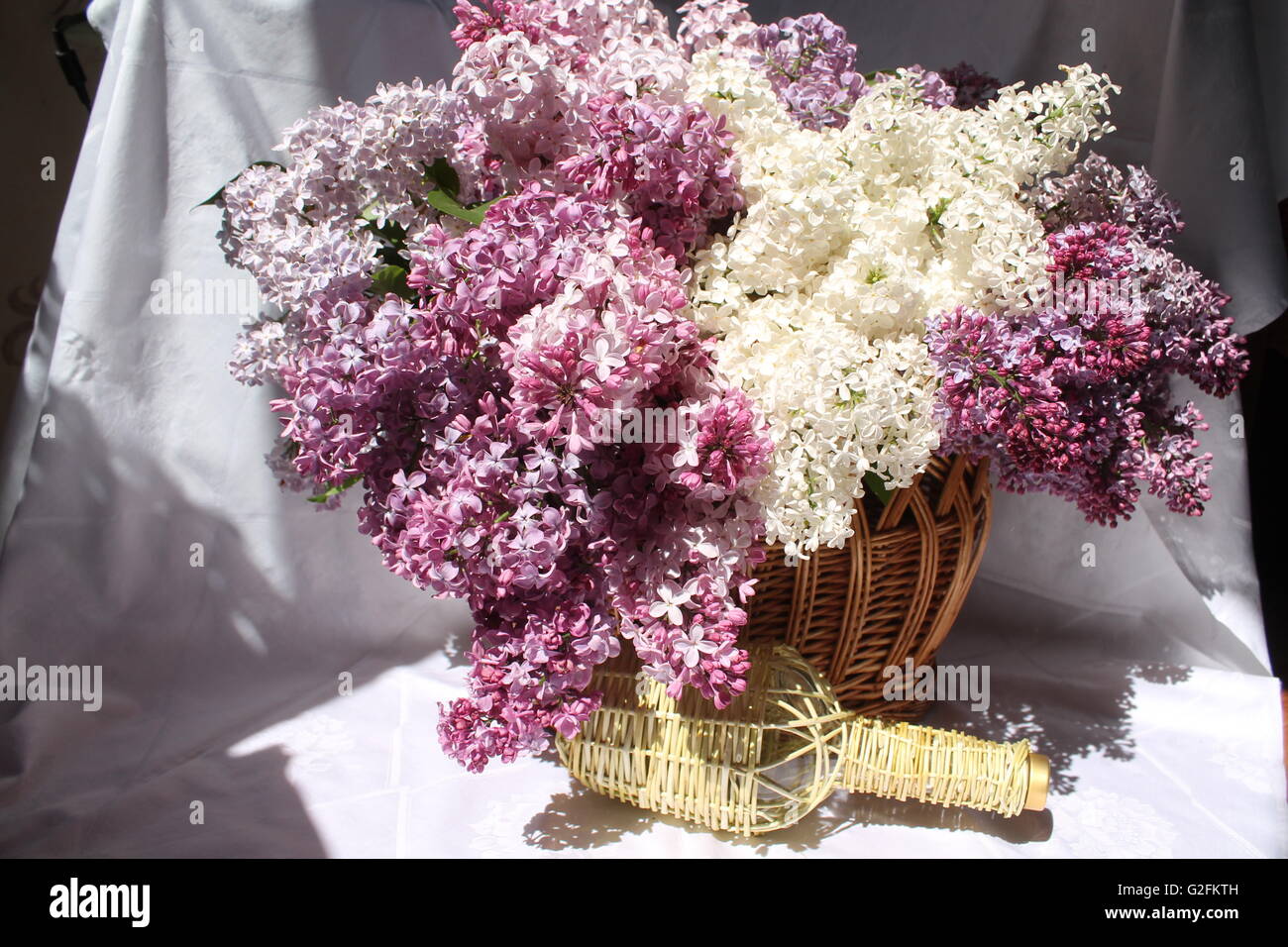 Pomposo bouquet da giardino lilla diversi tipi in willow cesto con bottiglia di vetro( artigianato cose dalla decorazione della casa) Foto Stock