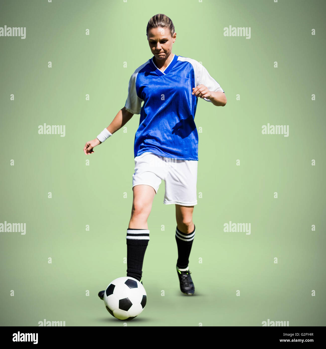 Immagine composita della donna giocatore di calcio procedendo con una sfera Foto Stock