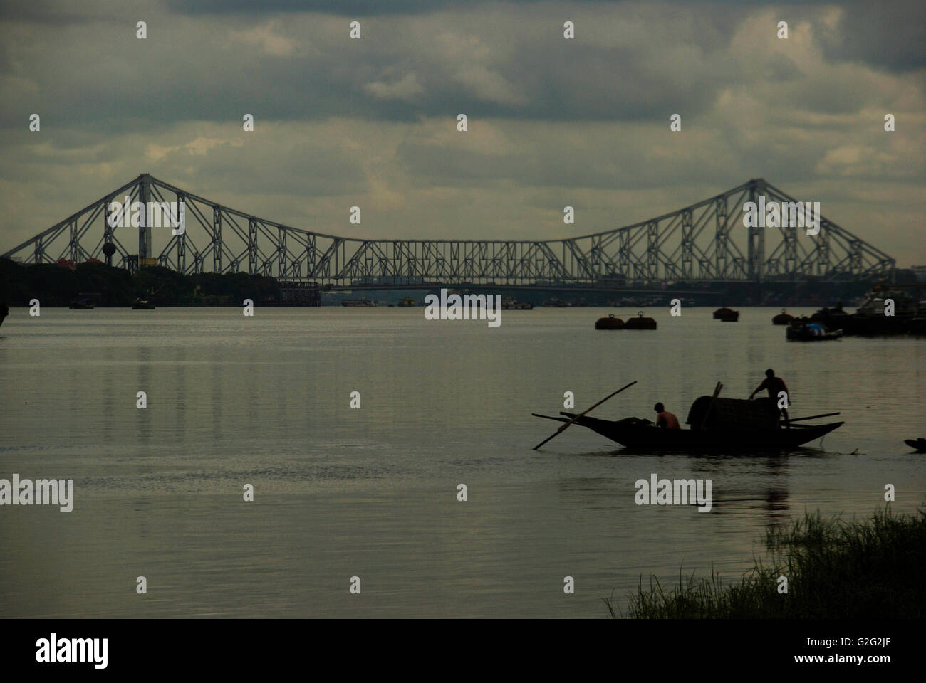 Quella di Howrah Bridge e il Fiume Hooghly con pioggia nuvole, Calcutta, West Bengal, India Foto Stock