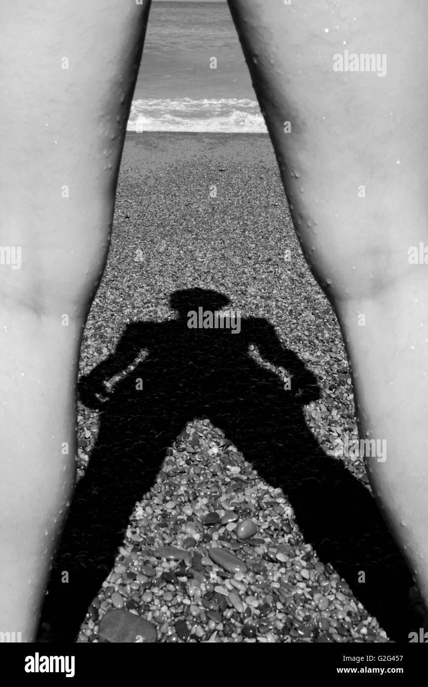 Ombra di donne tra due gambe sulla spiaggia Foto Stock