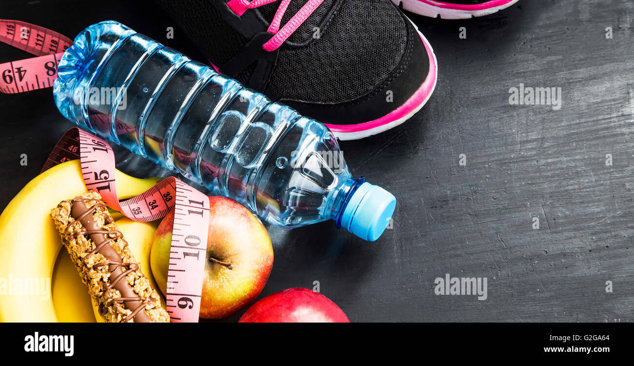 Frutti, acqua in bottiglia, barra di cereali e scarpe da ginnastica, sport  itmes, uno stile di vita sano Foto stock - Alamy