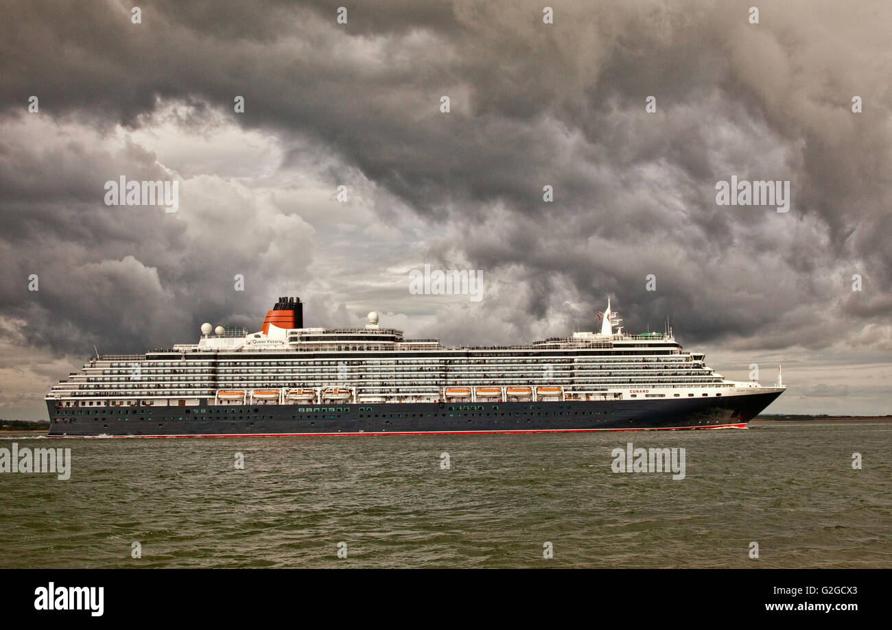 Cunard liner Queen Victoria uscire Southampton arrotondamento Calshot Spit sulla costa sud dell'Inghilterra sotto un cielo tempestoso Foto Stock