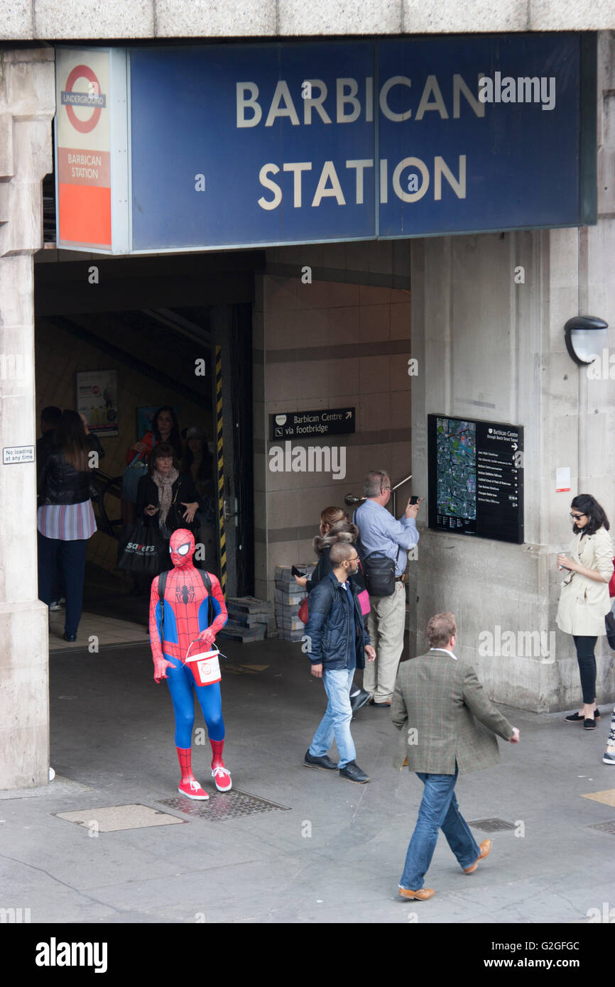 Fancy Dress collettore di carità al di fuori della stazione di Barbican in spiderman vestito con benna di raccolta Foto Stock