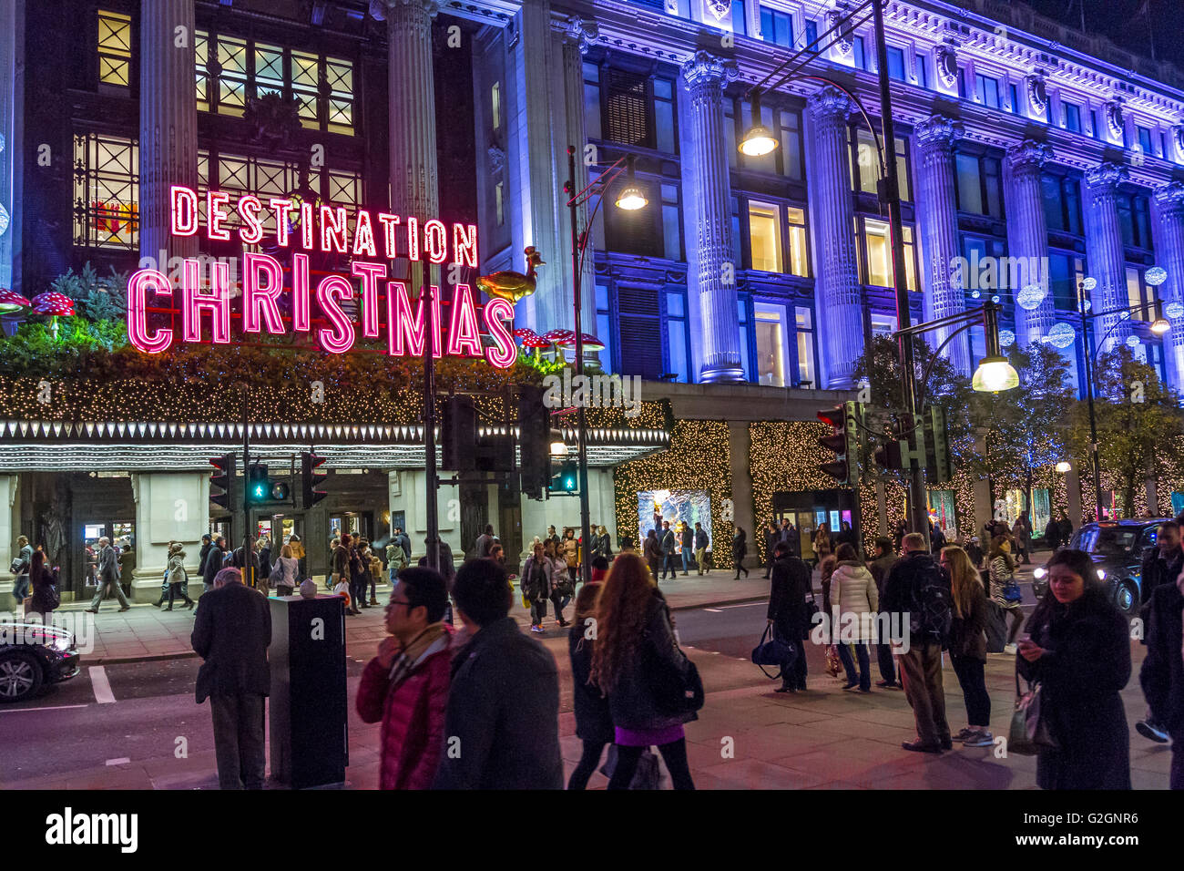 Cartello al neon 'Demination Christmas' sopra l'entrata principale del grande magazzino Selfridges su Oxford St di Londra, occupato da amanti dello shopping natalizio, Londra Foto Stock