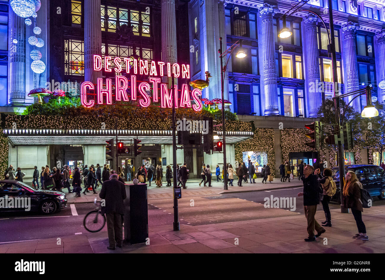 Cartello al neon 'Demination Christmas' sopra l'entrata principale del grande magazzino Selfridges su Oxford St di Londra, occupato da amanti dello shopping natalizio, Londra Foto Stock