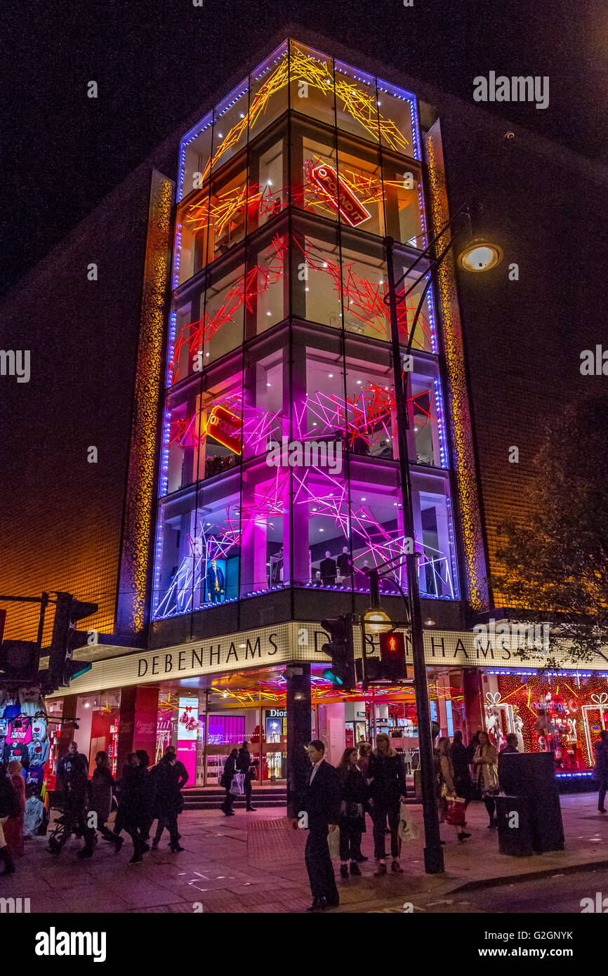 La gente che cammina ha passato il grande magazzino di Debenhams su Oxford St a Natale che è stato decorato con le luci di Natale, Londra, Regno Unito Foto Stock