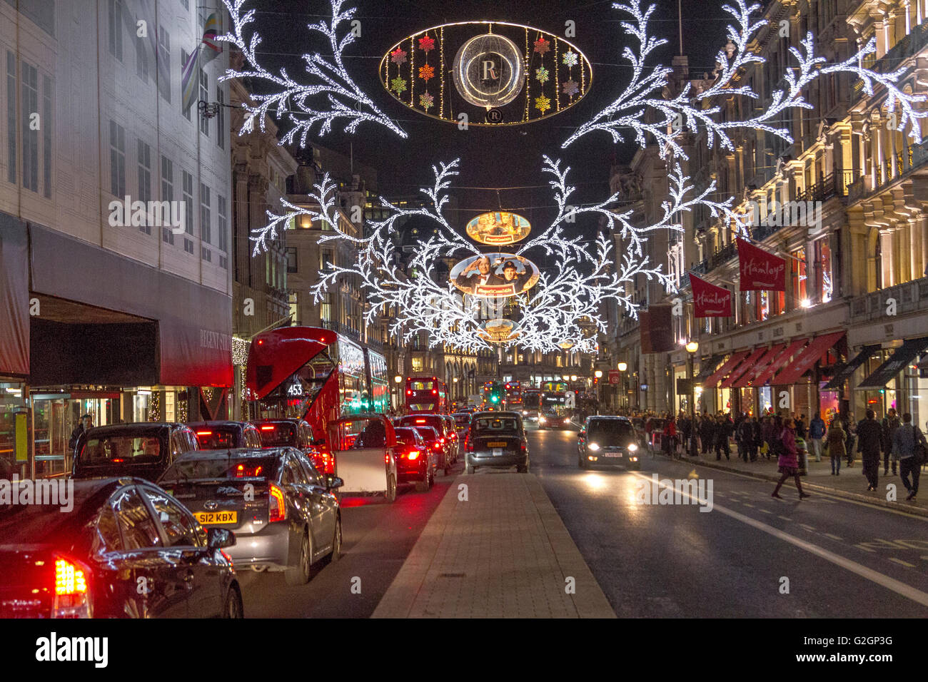 Luci di Natale lungo una trafficata via Regent affollata di acquirenti nel periodo natalizio nel West End di Londra Foto Stock