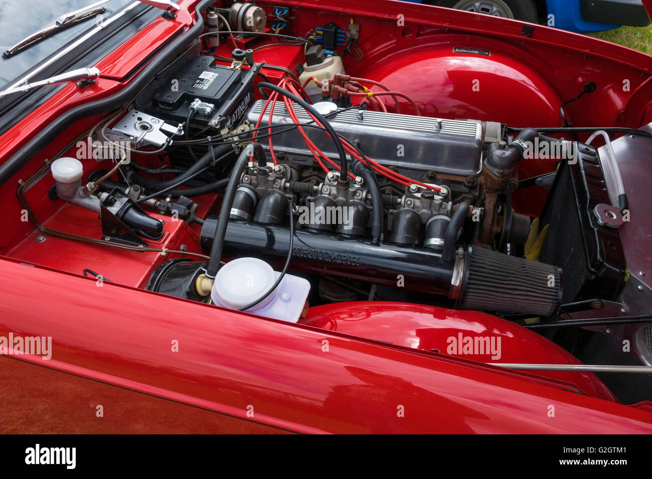 Un classico rosso Triumph GT6 a sei cilindri auto sportiva con cofano motore aperto per mostrare il motore Foto Stock