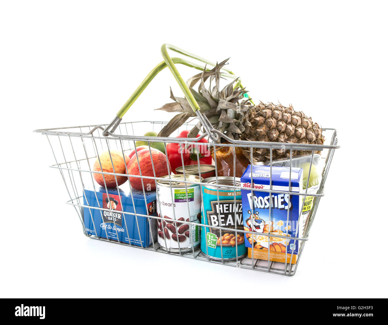 Selezione di verdure e di generi alimentari in un filo Shopping Basket su sfondo bianco Foto Stock