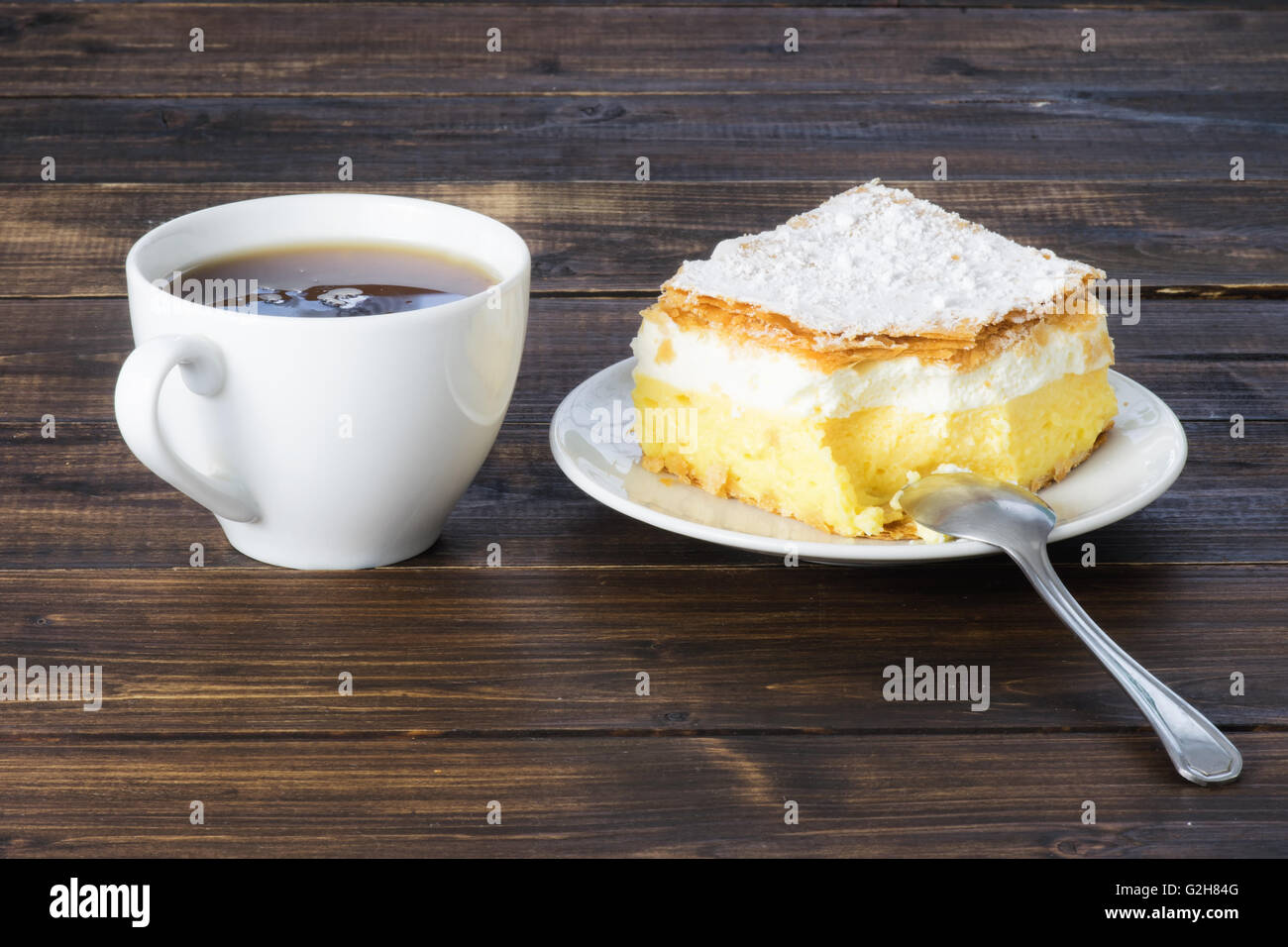 Bollitore per tè e una pace della crema vaniglia torta Foto Stock