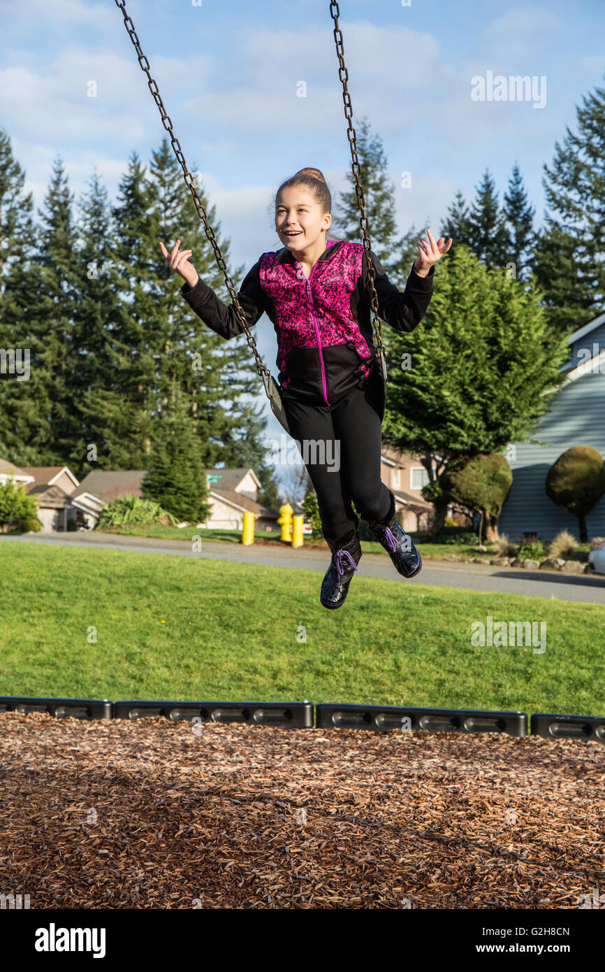 Dieci anni di ragazza senza oscillazione appesa in un parco giochi in Issaquah, Washington, Stati Uniti d'America Foto Stock