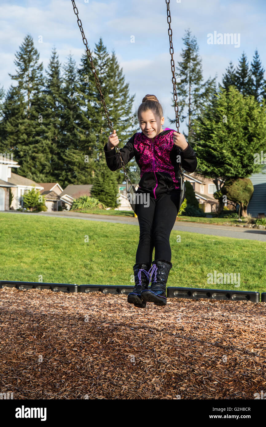 Ragazza di 10 anni su un altalena in un parco giochi in Issaquah, Washington, Stati Uniti d'America Foto Stock
