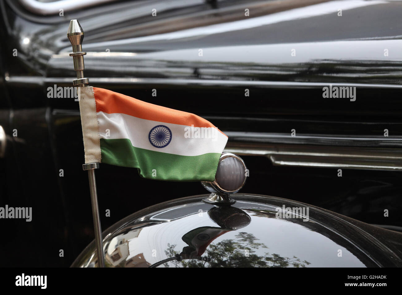 Il tricolore bandiera indiana impostato su un vecchio nero auto d'epoca. Foto Stock