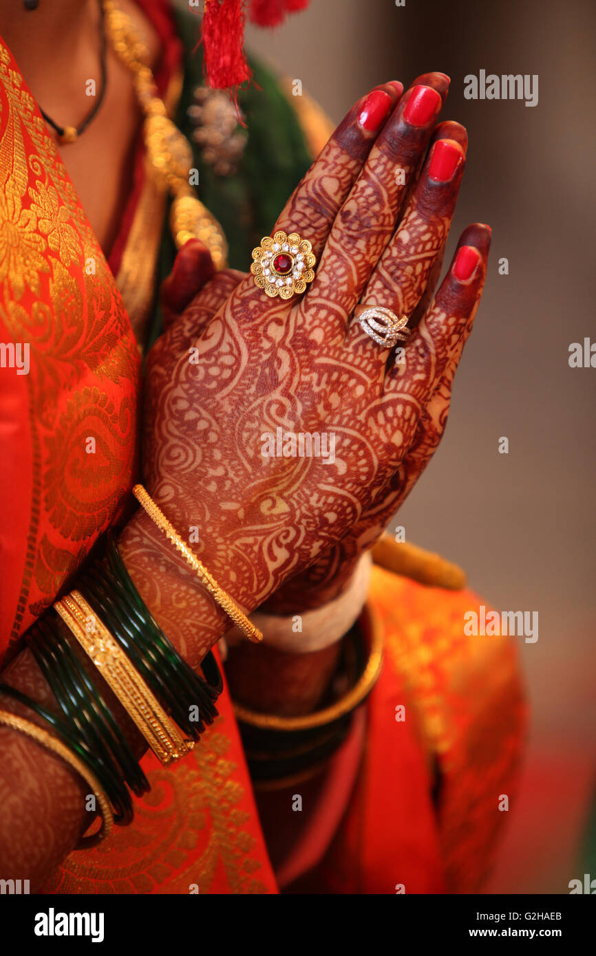 Ripiegate henna decorate le mani di un indiano sposa durante una preghiera in un tradizionale matrimonio indiano Foto Stock