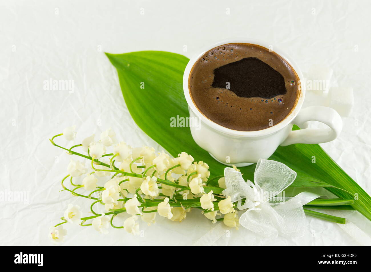 Tazza di caffè e il giglio della valle dei fiori Foto Stock