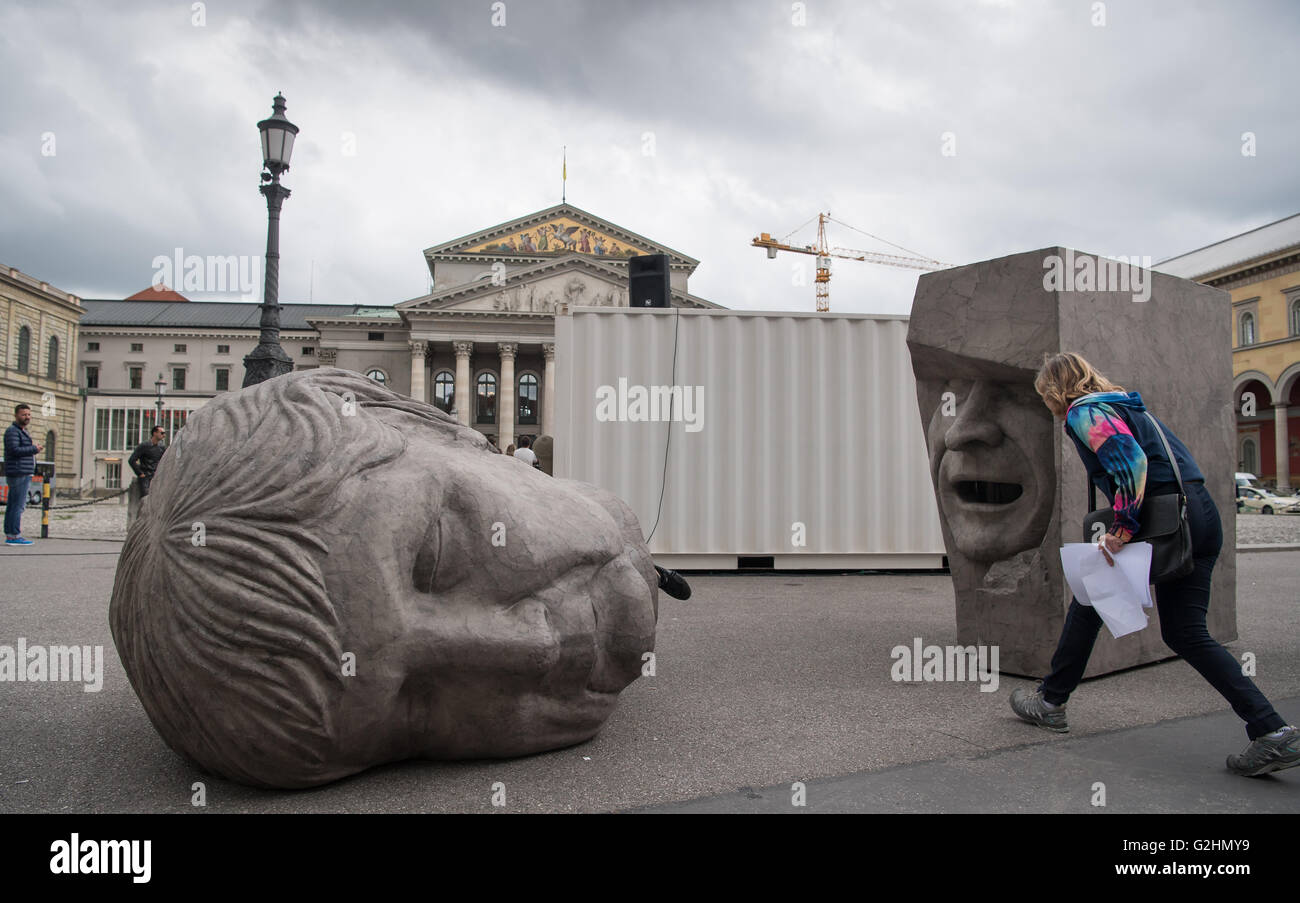 Monaco di Baviera, Germania. 31 Maggio, 2016. Grigio a due teste di cartone del Cancelliere Angela Merkel (l) e Mario Draghi (r) che giace di fronte all'Opera di Stato Bavarese di Monaco di Baviera, Germania, il 31 maggio 2016. La scultura è parte delle prestazioni 'Die Irrenden. Europaeische Defiguration' dell'arte duo 'Bankleer', che è andata in scena tra il 1 e 12 giugno tutti i giorni dalle 4 alle 8 pm durante condizioni di secco a Max-Joseph-Platz a Monaco di Baviera. Foto: PETER KNEFFEL/dpa/Alamy Live News Foto Stock