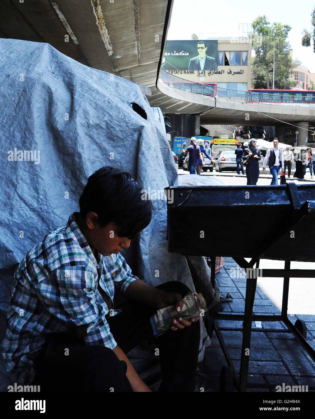 Damasco, Siria. 31 Maggio, 2016. Un ragazzo siriano conta dei soldi che ha guadagnato dalla vendita di caramelle in una bancarella di strada in Damasco Capitale della Siria, il 31 maggio 2016. © Ammar/Xinhua/Alamy Live News Foto Stock