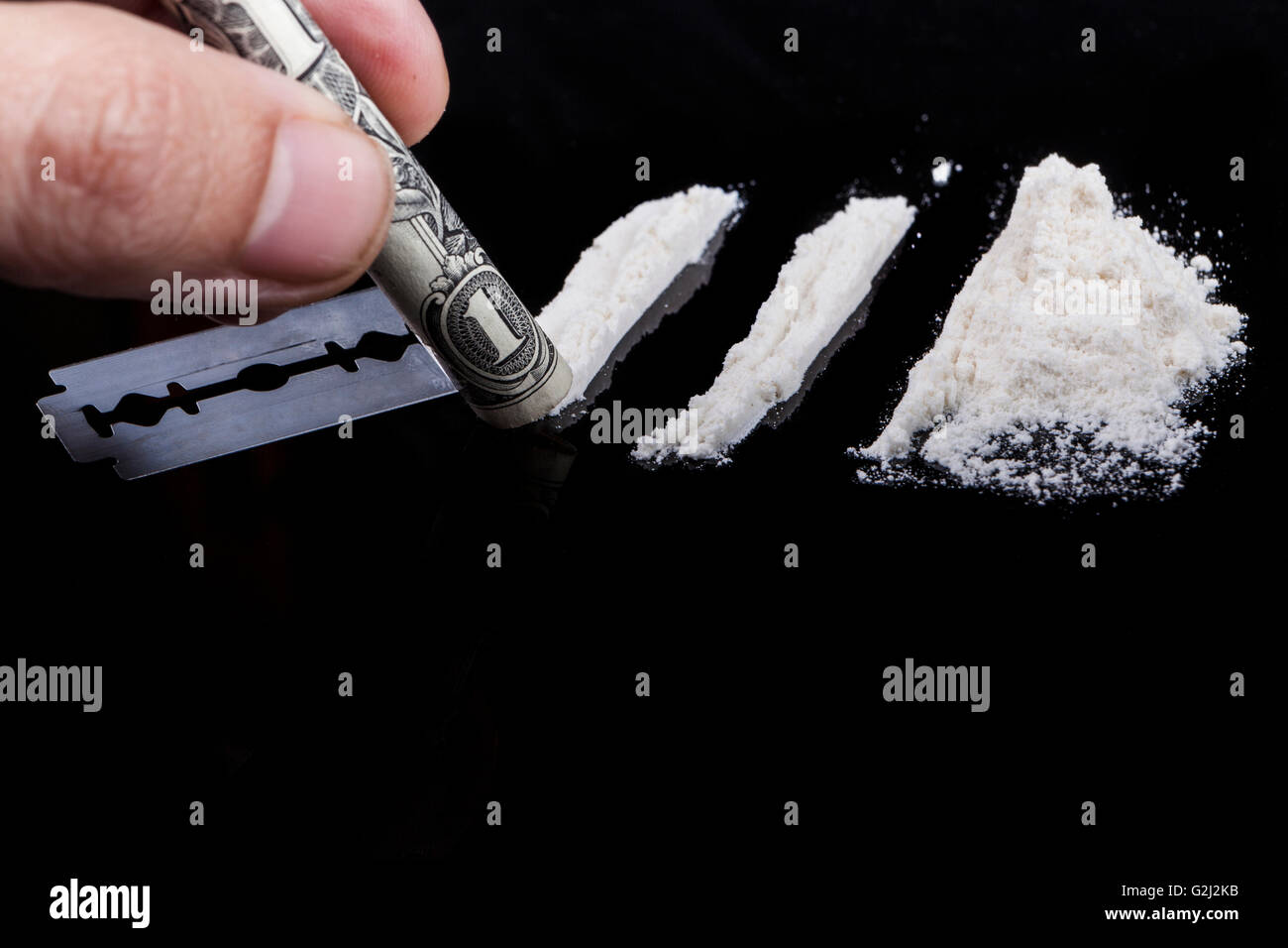 Bianco in polvere del farmaco con la lama di un rasoio e laminati uno dollar banconota Foto Stock