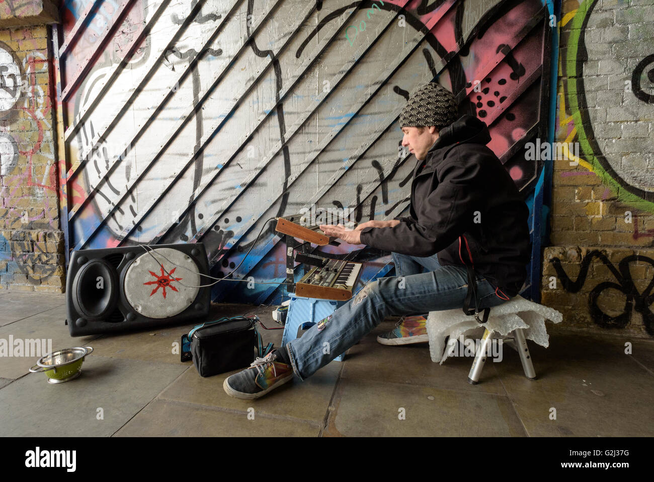 Suonatore ambulante elettronico consente di riprodurre la musica su un sistema audio portatile in un tunnel su Wheler street in London Shoreditch, E1, Inghilterra Foto Stock