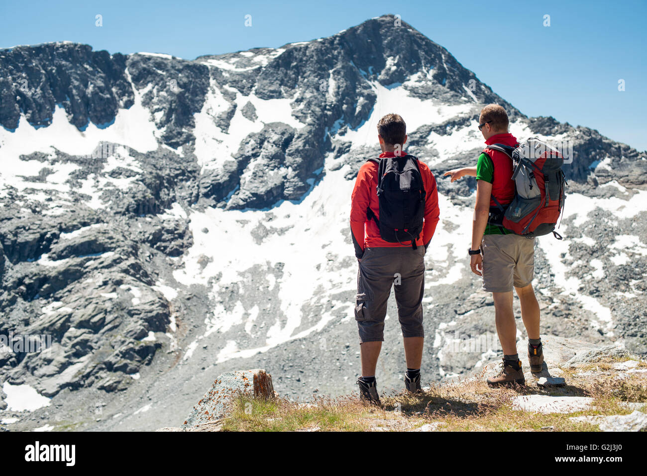 Due escursionisti Visualizzazione delle montagne innevate, vista posteriore, Col du Petit Mont Cenis, Val Cenis Vanoise, Francia Foto Stock