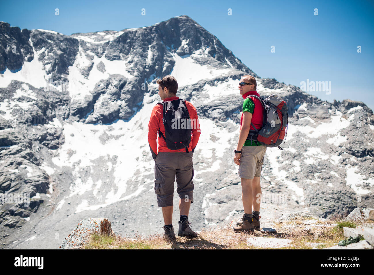 Due escursionisti Visualizzazione delle montagne innevate, vista posteriore, Col du Petit Mont Cenis, Val Cenis Vanoise, Francia Foto Stock
