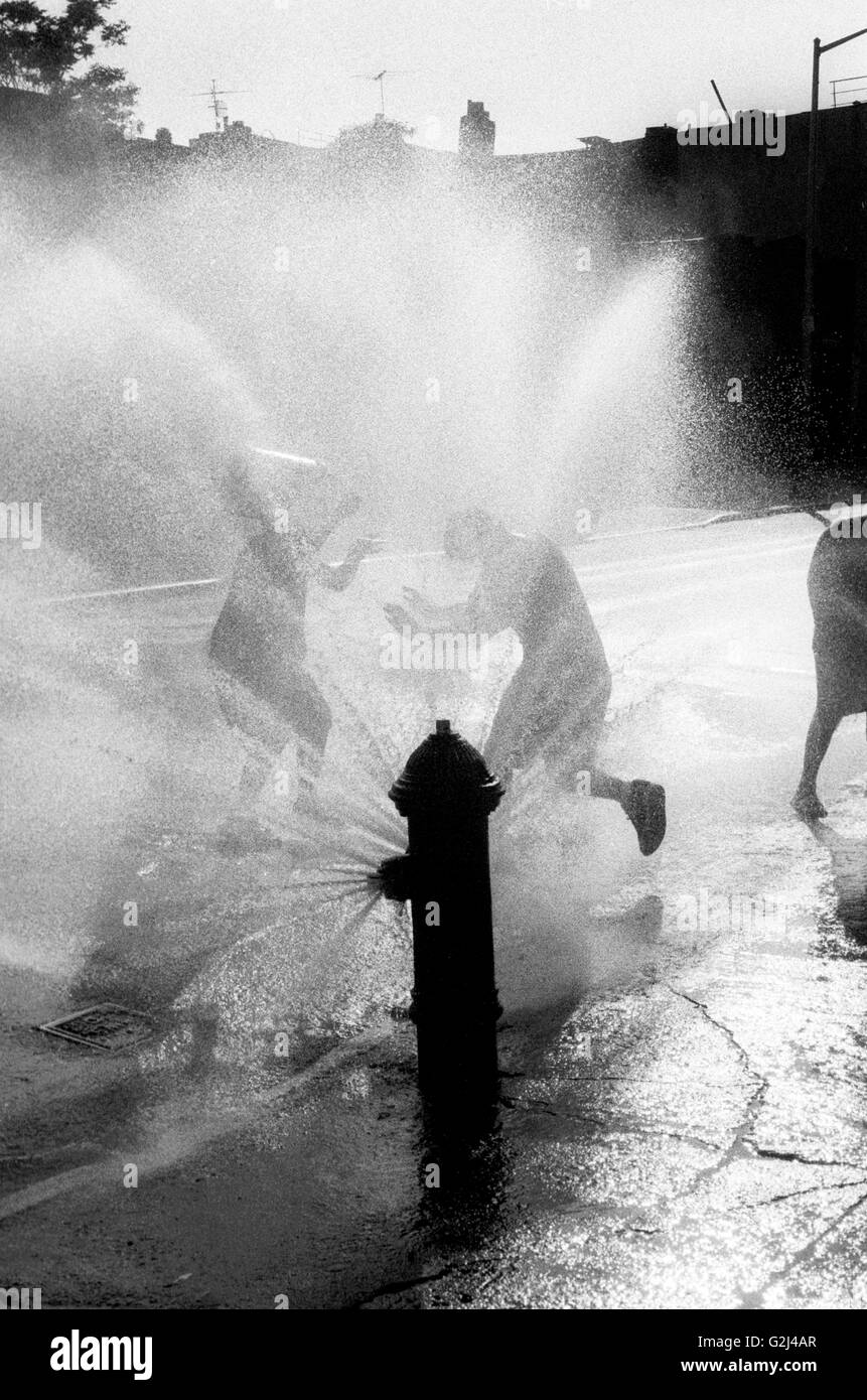 Bambini che giocano a pioggia o spruzzo d'acqua Idrante Foto Stock