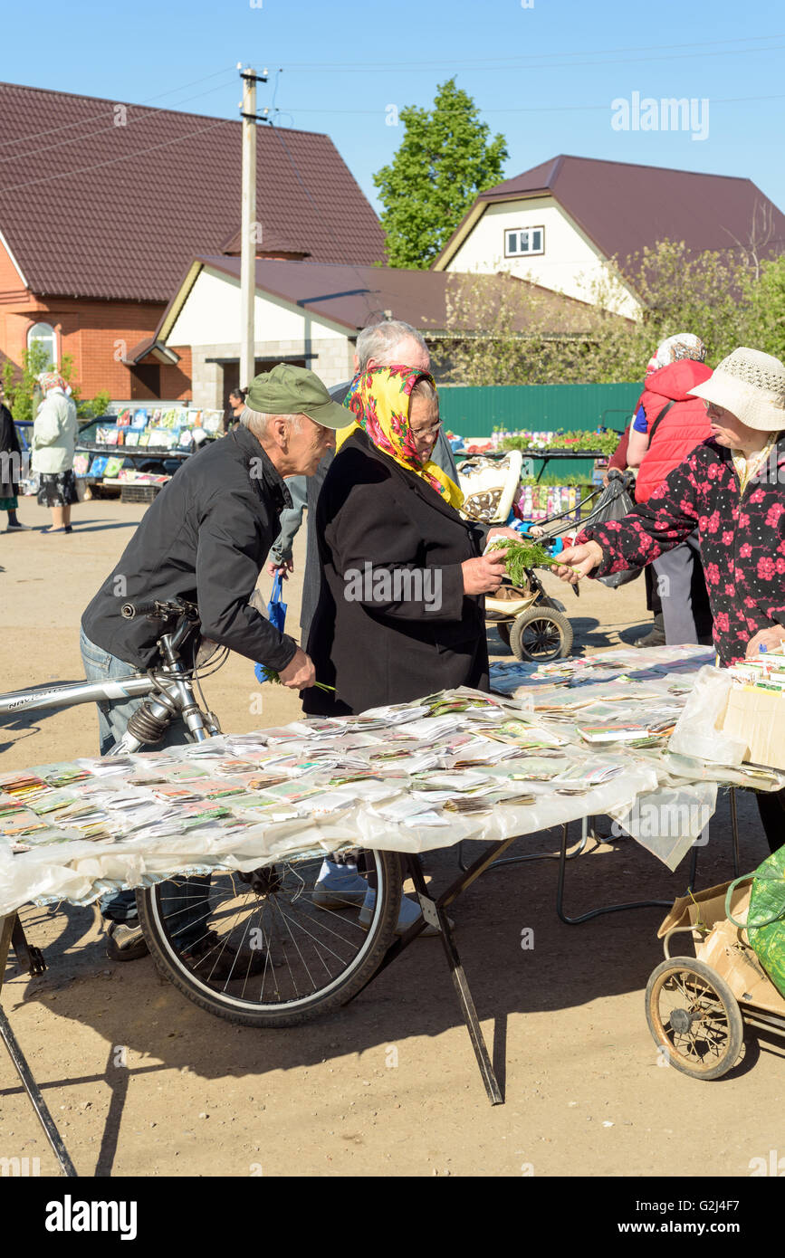 Un seme russo venditore vende pacchetti di sementi di ortaggi ai membri del pubblico in Raevka, Russia nel maggio 2016 Foto Stock