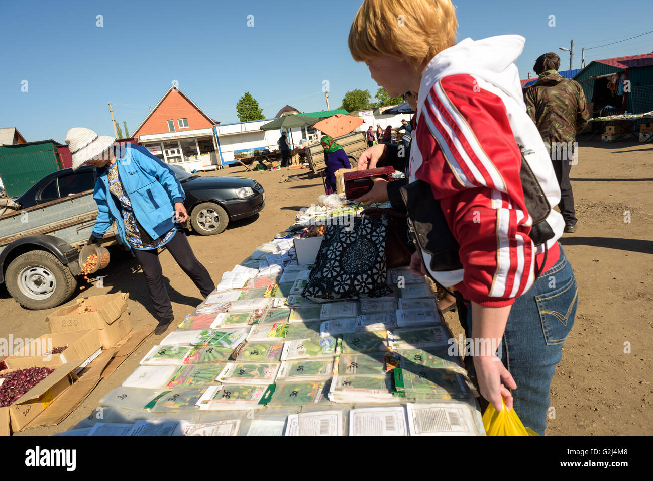 Un seme russo venditore vende pacchetti di sementi di ortaggi ai membri del pubblico in Raevka, Russia nel maggio 2016 Foto Stock