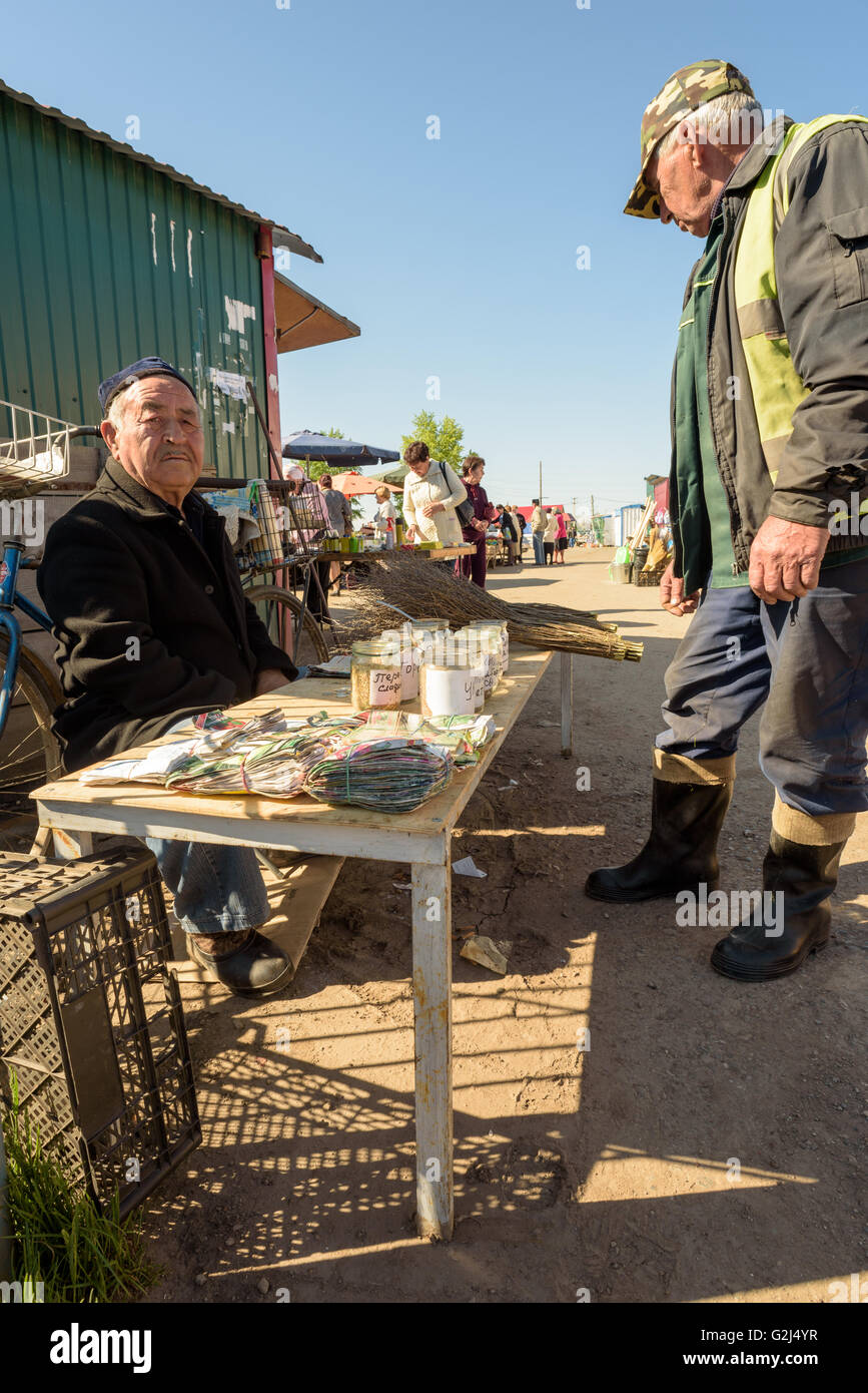 Età compresa tra uomo anziano da Tashkent vende home prodotti semi vegetali per la vendita presso il locale mercato degli agricoltori in Russia Foto Stock