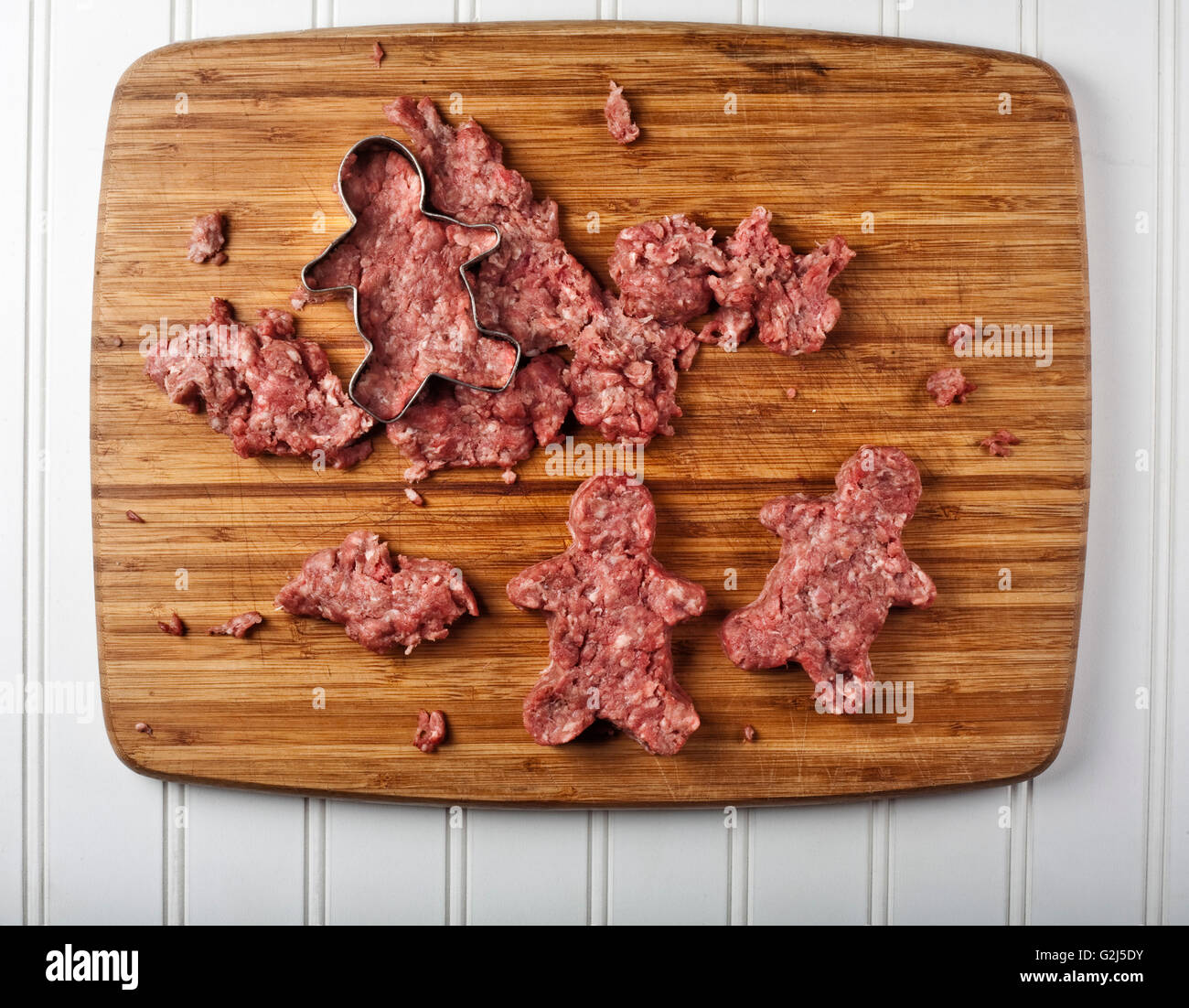 Cookie Cutter rendendo la Carne di Suolo in forma di panpepato Uomini su un tagliere, ad alto angolo di visione Foto Stock