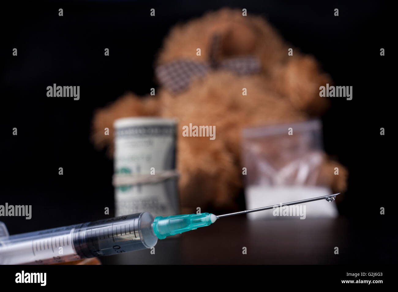 Caduta di farmaco siringa closeup con taddy bear in background Foto Stock
