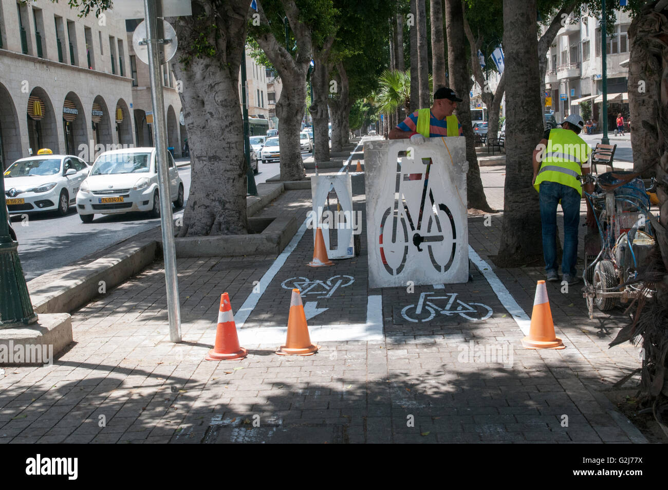 Lavoratori municipali contrassegnare una pista ciclabile. Fotografato a Jaffa, Israele Foto Stock