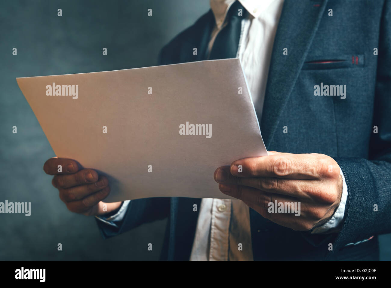 Imprenditore leggendo la documentazione di progetto, ben vestito ufficio business manager analizzando il documento. Foto Stock