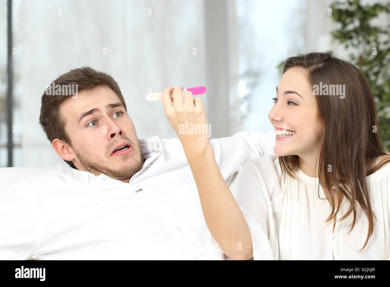 Excited donna rimanere incinta per mantenere la sua paura non partner pronto a casa interno Foto Stock